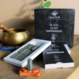 Natural incense smudge bricks and black wood burner set on a wooden surface.