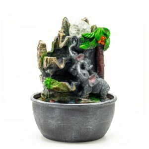 Tabletop water feature with elephants and palm tree, creating a serene ambiance.