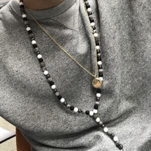 Multi beads gemstone necklace featuring an angel wing pendant.