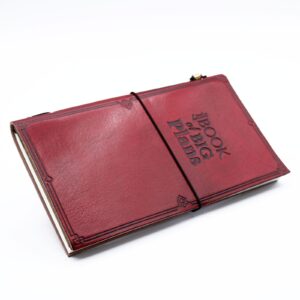 Handmade red leather journal with embossed design and wrap-around band.
