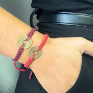 Colourful handmade friendship bracelets featuring a lucky Feng Shui coin.