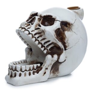 Skull-shaped backflow incense burner with smoke cascading downwards.