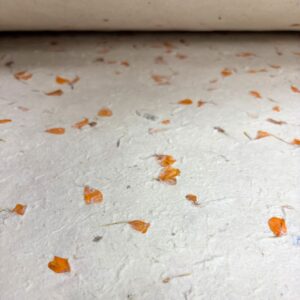 Handmade Lokta wrapping paper with marigold petals, perfect for crafts.