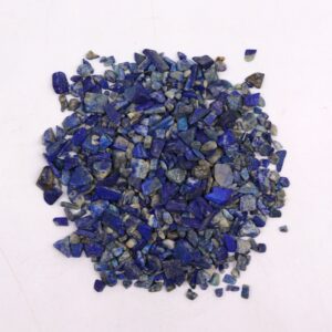 Bulk Lapis gemstone chips in a natural setting, ideal for crafts and decor.