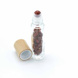 Red Jasper essential oil roller bottle with wooden cap and polished stone ball.