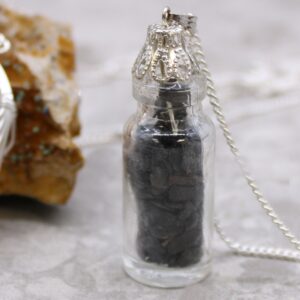 Elegant black onyx necklace in a decorative bottle with a delicate cap.