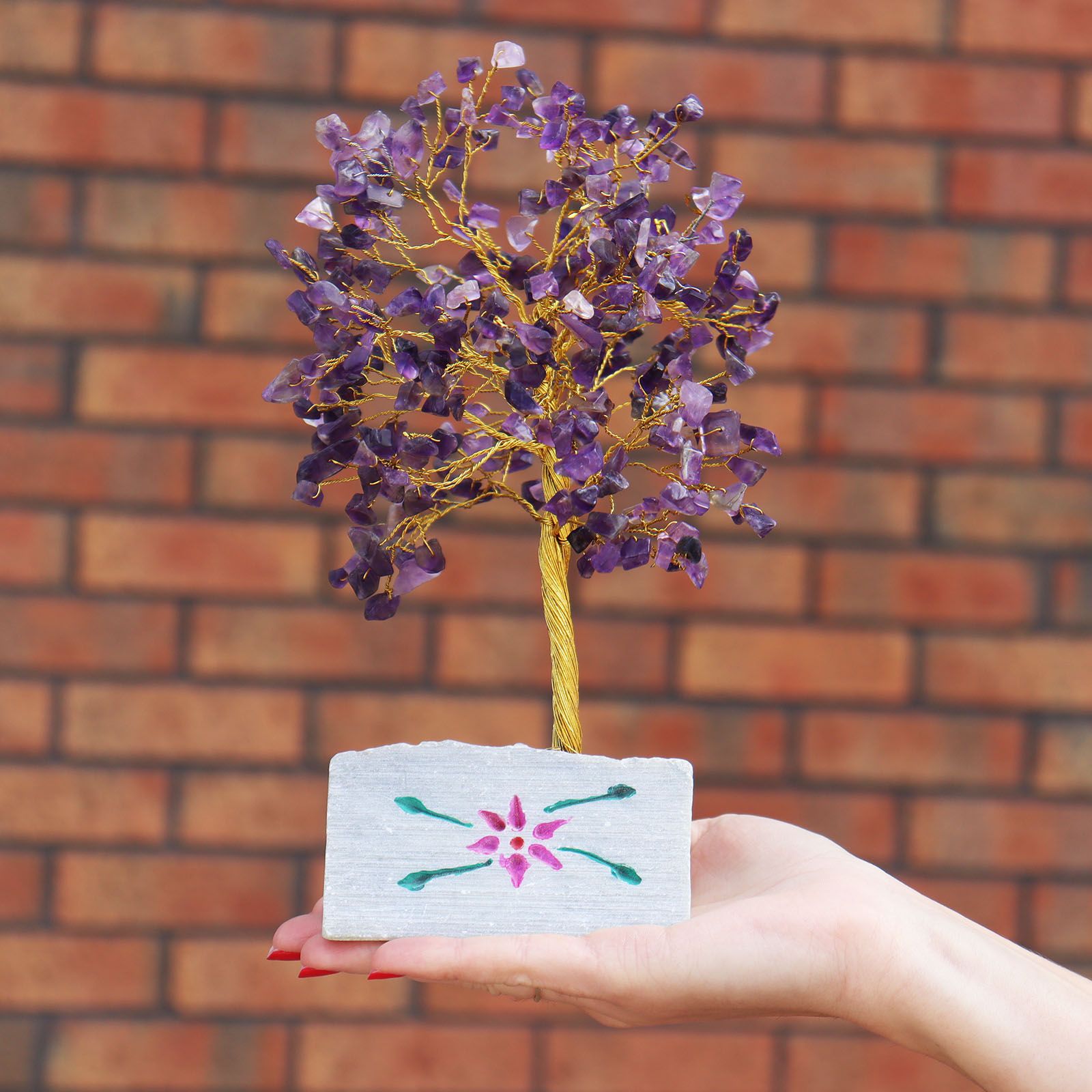 Handmade amethyst gemstone tree mounted on a natural rock base.