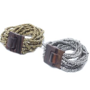 Assorted gold and bronze multi-bead bangle with wooden clasp on a neutral background.