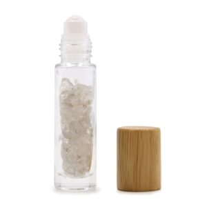 Rock quartz essential oil roller bottle with wooden cap and gemstones inside.