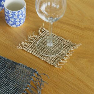 Handwoven natural seagrass coasters with fringe detailing for stylish table settings.