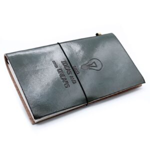 Handmade grey leather journal with embossed design and wrap-around band.