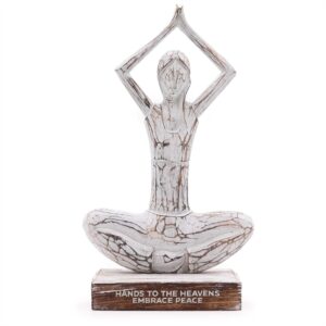 Whitewashed wooden yoga lady figurine in hands up pose, embracing peace.