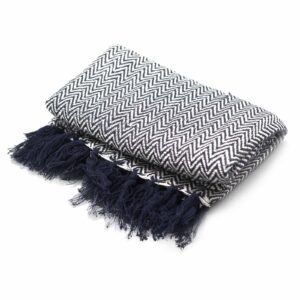 Navy zigzag cotton throw with tasselled edges, perfect for cosy evenings.