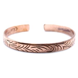 Slim copper Tibetan bracelet featuring intricate tribal swirl designs.