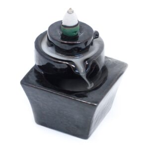 Elegant backflow incense burner with cascading smoke effect in a unique design.