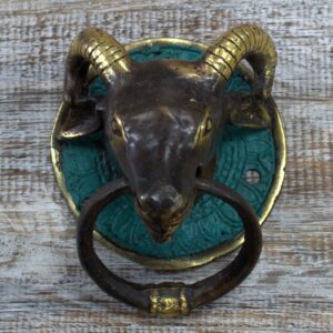 Brass door knocker in the shape of a ram's head, perfect for welcoming guests.