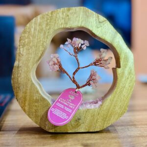 Delicate Rose Quartz gemstone tree in a mango wood ring, showcasing natural beauty.