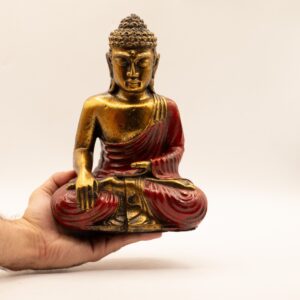 Large red and gold Buddha statue in classic Varada Mudra pose.