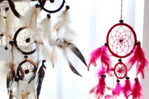 Large round rainbow dream catcher with intricate details and vibrant colours.