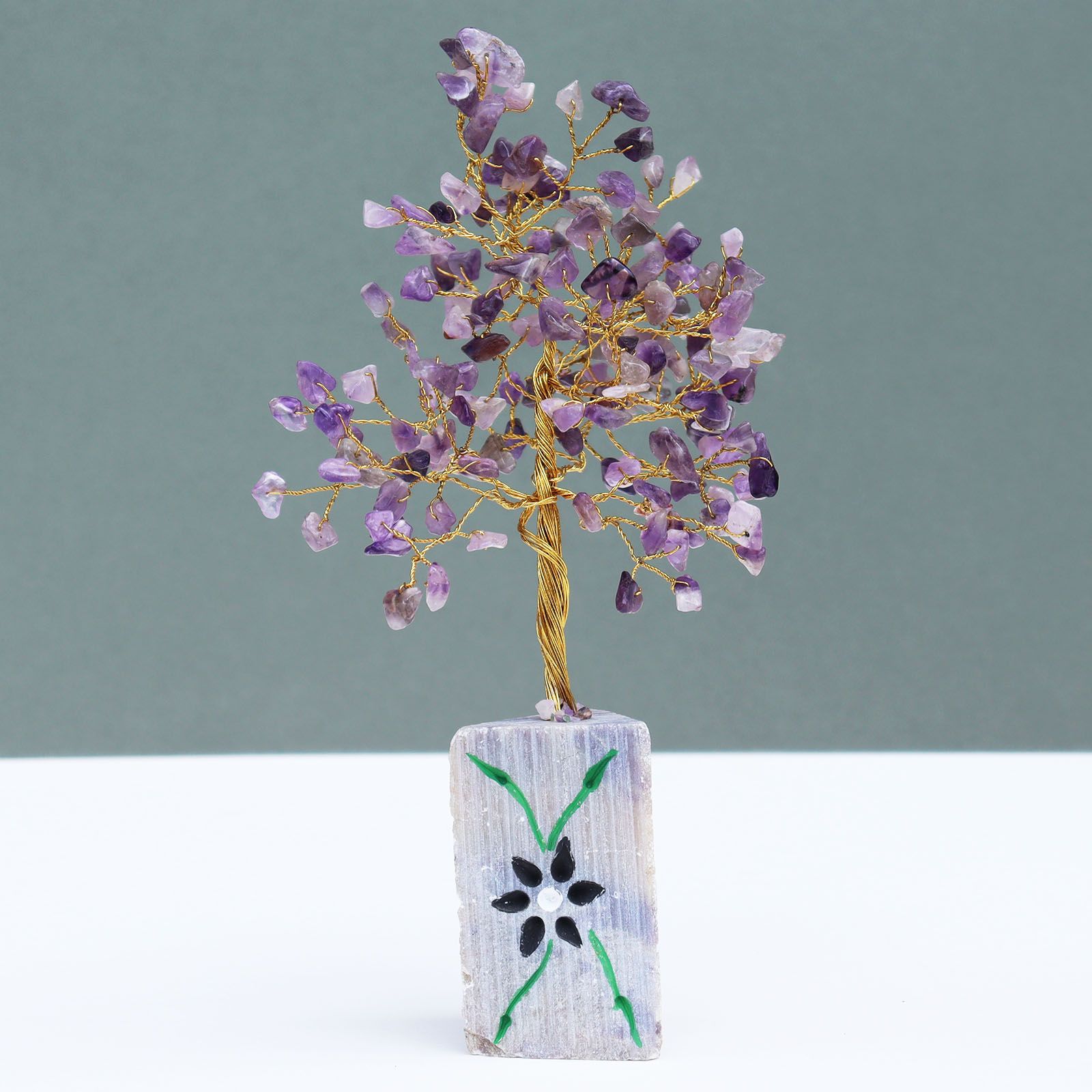 Handmade amethyst gemstone tree with natural rock base for home decor.