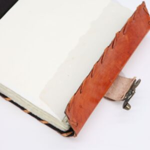 Light brown tan book featuring evil eye decor with deckle edges.