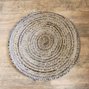 Handmade round jute and recycled denim rug, soft and durable, perfect for home decor.