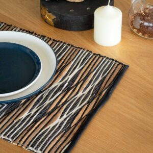 Natural placemat with a striking black and white waves pattern, made from water hyacinth.