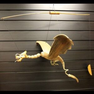 Handmade coconut dragon mobile with impressive wingspan for garden display.