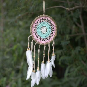 Pastel pink macramé dream catcher with feathers, handmade in Bali.