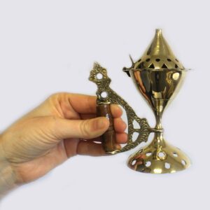 Polished brass cone burner with wooden handle, ideal for incense and home fragrance.