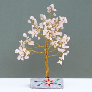 Handmade rose quartz gemstone tree mounted on a rock base for home decor.