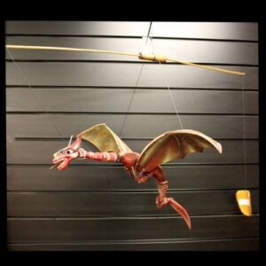 Handmade coconut dragon mobile with impressive wingspan for garden display.