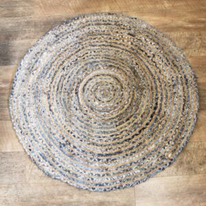 Handmade round jute and recycled denim rug, soft and durable, perfect for home decor.