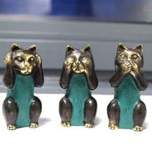 Handmade brass cats representing See No, Hear No, Speak No Evil in neutral tones.