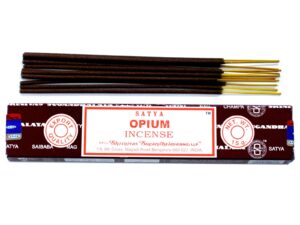 Satya Incense sticks in a decorative holder, releasing aromatic smoke.