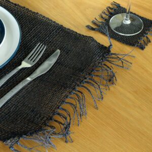 Handcrafted black seagrass placemat with fringe details for dining decor.