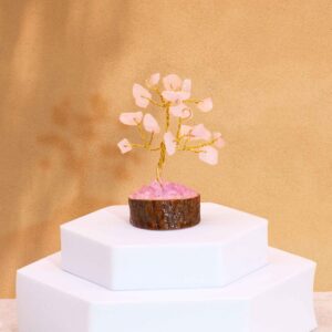 Mini gemstone tree with rose quartz stones on a wooden base.